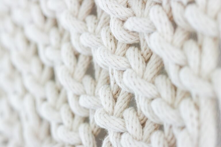 Cream textured crochet fabric resting on a wooden table